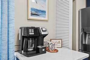 Eine Küche mit Kaffeemaschine, einem gerahmten Bild und einem Wasserspender.