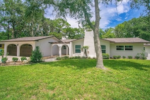 A two-story house with a covered patio, a white exterior, and a well-maintained lawn. - Gem at Crystal River (Crystal River)