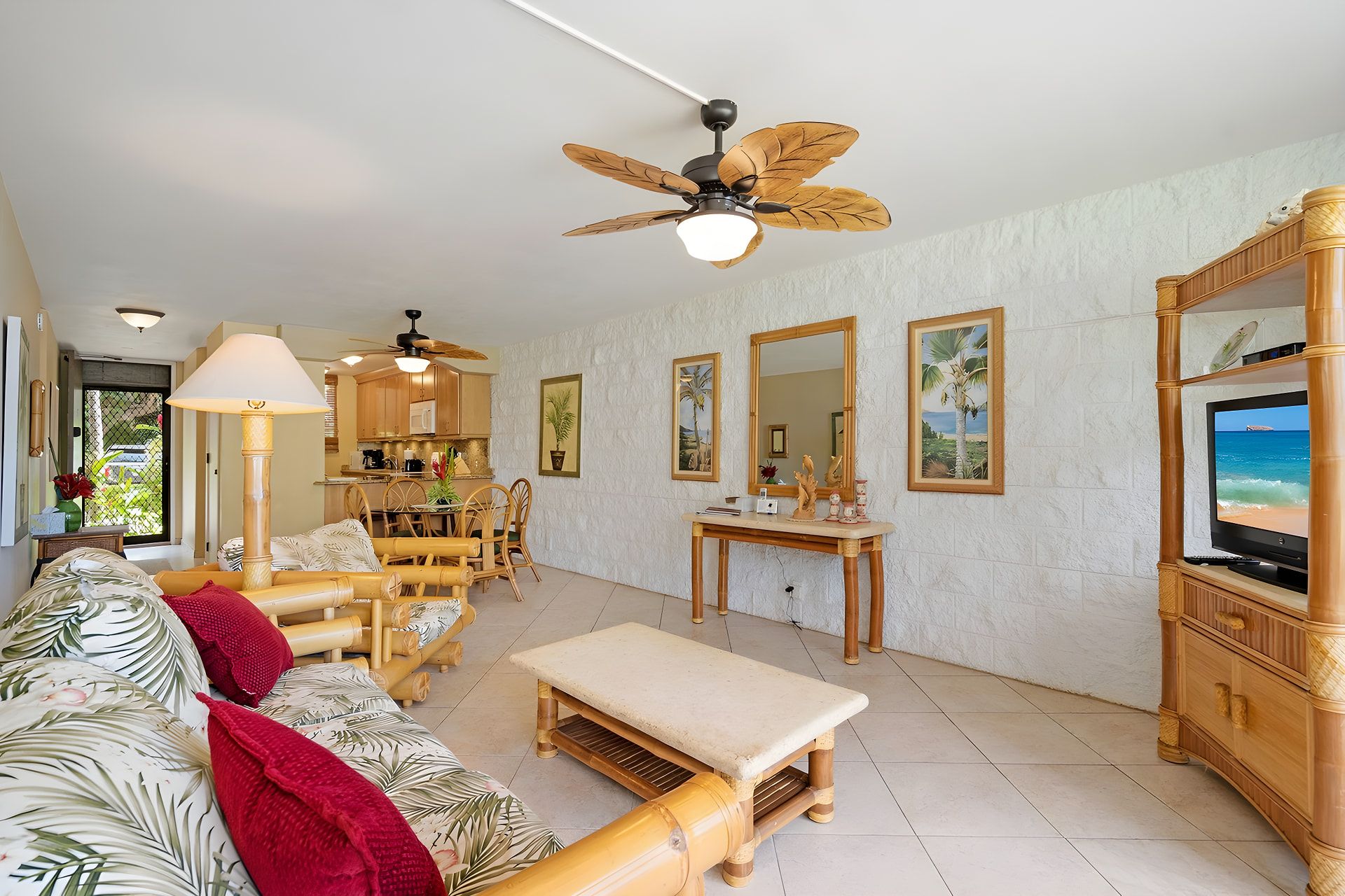 A spacious living room with a ceiling fan, a television, and a dining area with wooden furniture.