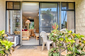 Ein Hotelzimmer mit einer Schiebetür zum Balkon, einer Sitzecke mit Tisch und Stühlen sowie einem Blumentopf.