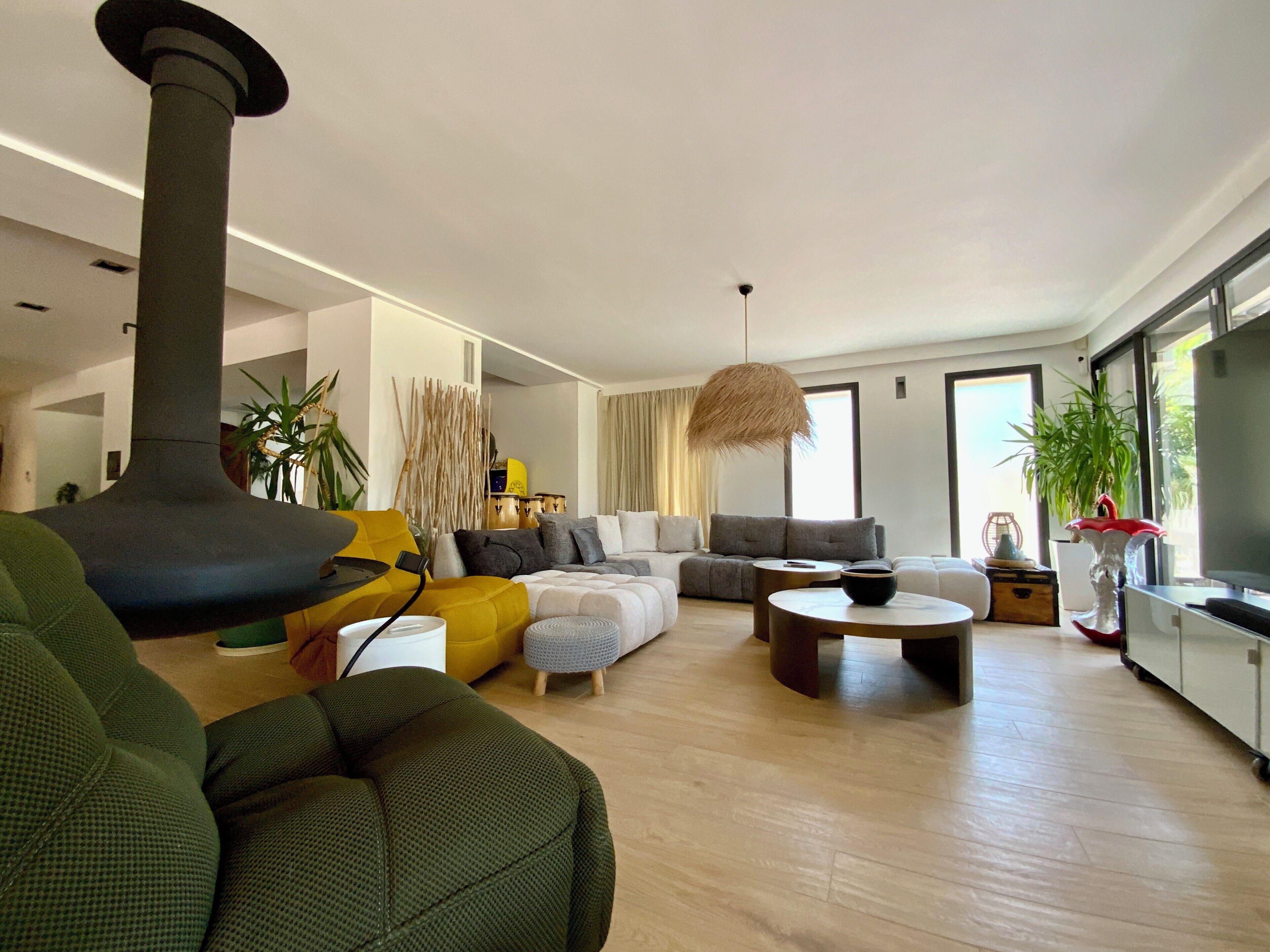 A modern living room with a fireplace, sofas, a coffee table, and a TV.