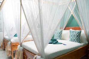 A four-poster bed with a canopy, a wooden headboard, and patterned pillows.