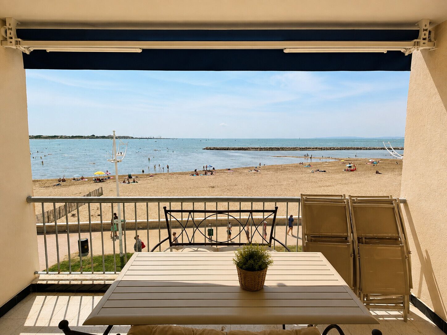 A balcony with a view of a beach and the sea.