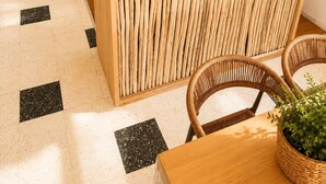 Una cucina moderna con isola centrale, elettrodomestici in acciaio inossidabile e zona pranzo con mobili in vimini.