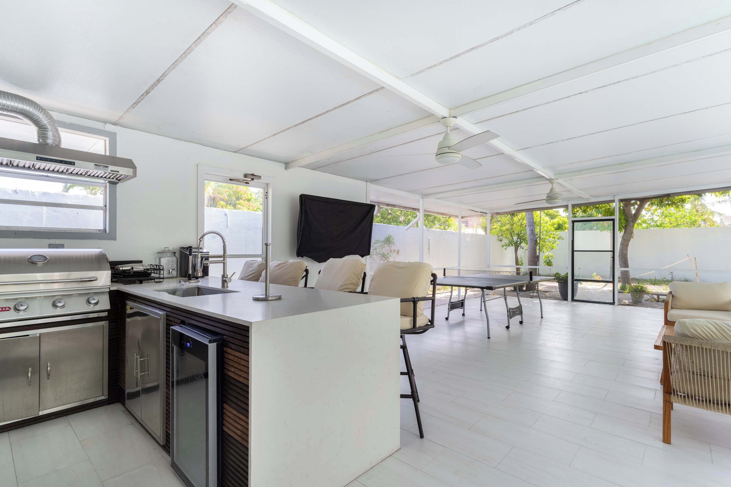 Una cocina moderna con una parrilla integrada, un fregadero y un lavavajillas. Hay una zona de comedor con una mesa y sillas.