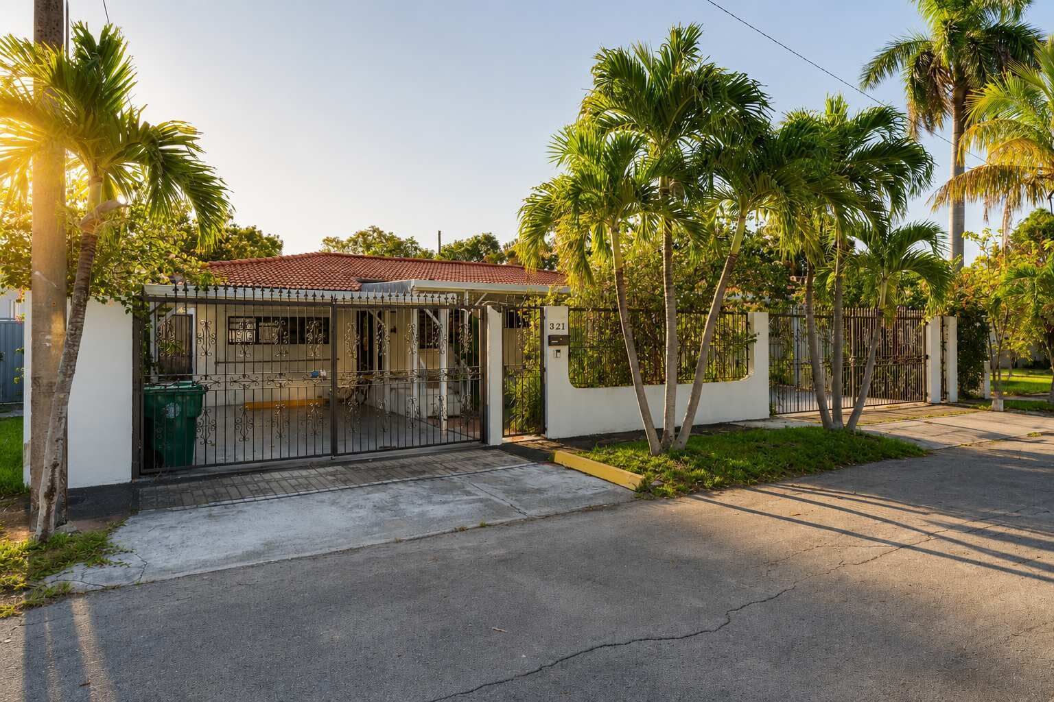 A residential property with a gated entrance, a covered porch, and a red-tiled roof.