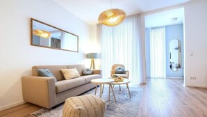 A modern living room with a sofa, armchairs, a coffee table, and a rug.