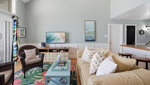 A living room with a sofa, a coffee table, a television, and a bookshelf. - Waterfront Condo 10 Min from Margaritaville! (Montgomery)