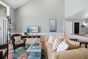 A living room with a sofa, a coffee table, a television, and a bookshelf. - Waterfront Condo 10 Min from Margaritaville! (Montgomery)
