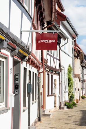 A traditional European building with a red sign indicating a townhouse. - Townhouse Duderstadt: Studio 1 (Duderstadt)