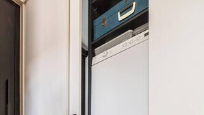 Une buanderie équipée d’un lave-linge à chargement frontal et d’un sèche-linge.
