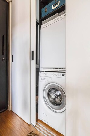 A laundry room with a front-loading washing machine and a dryer. - Hikari Haven Richmonds Creative Spirit near Cafs (Richmond)