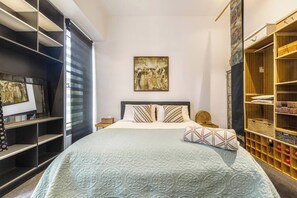 A bedroom with a bed, a large painting, a wardrobe, and a shelving unit. - Hikari Haven Richmonds Creative Spirit near Cafs (Richmond)