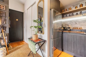 A modern kitchen with a stainless steel refrigerator, wooden cabinets, and a countertop with kitchen utensils. - Hikari Haven Richmonds Creative Spirit near Cafs (Richmond)
