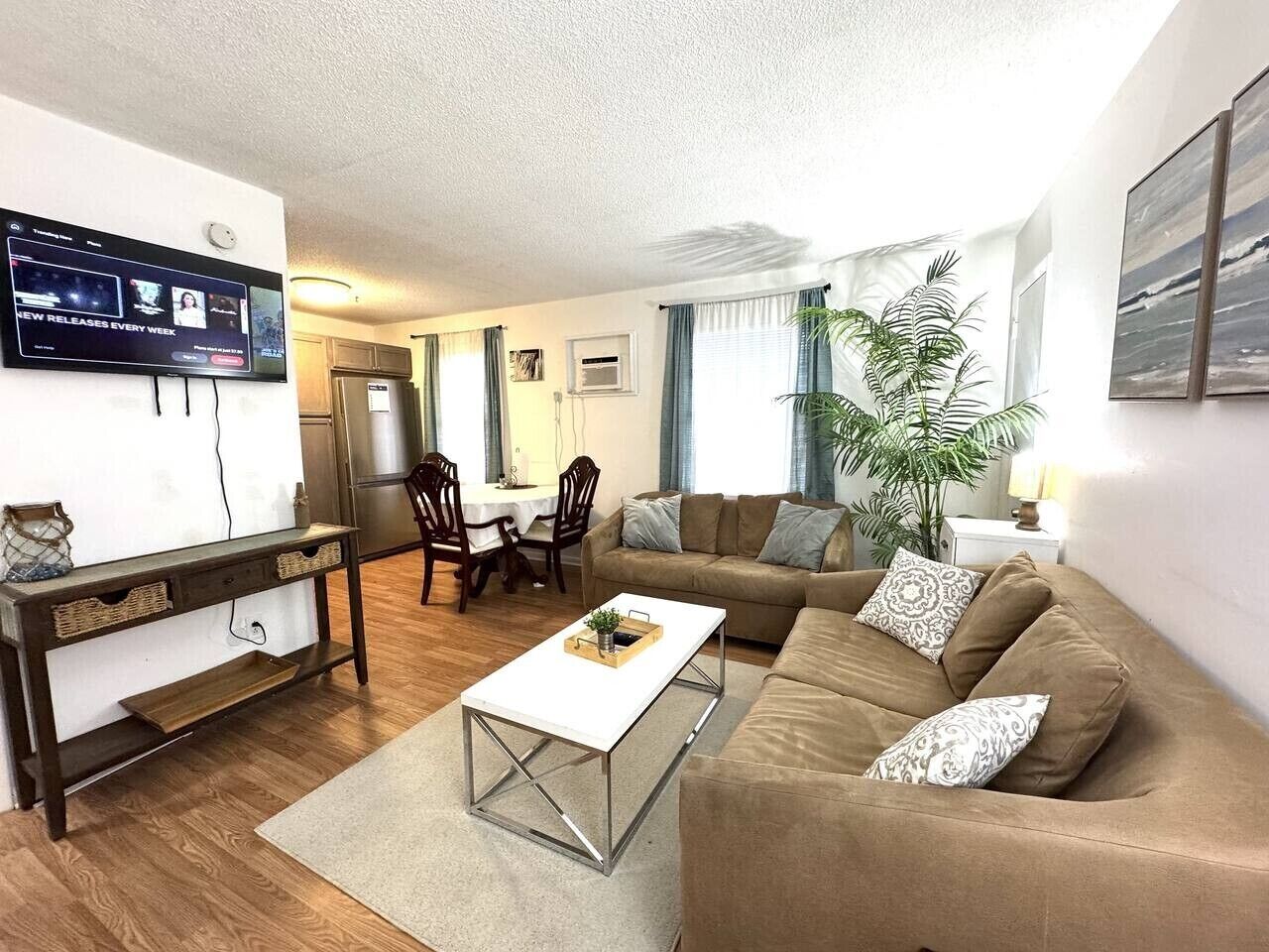 A living room with a sofa, coffee table, and a TV mounted on the wall.
