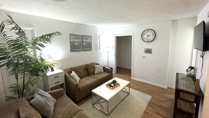 Un salon avec un canapé, une table basse et un téléviseur.