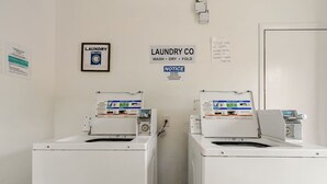 Une buanderie équipée de deux machines à laver et d’un panneau d’affichage.