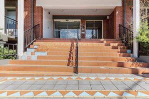 Ein Gebäudeeingang mit einer Treppe, die zu einer Glastür führt.