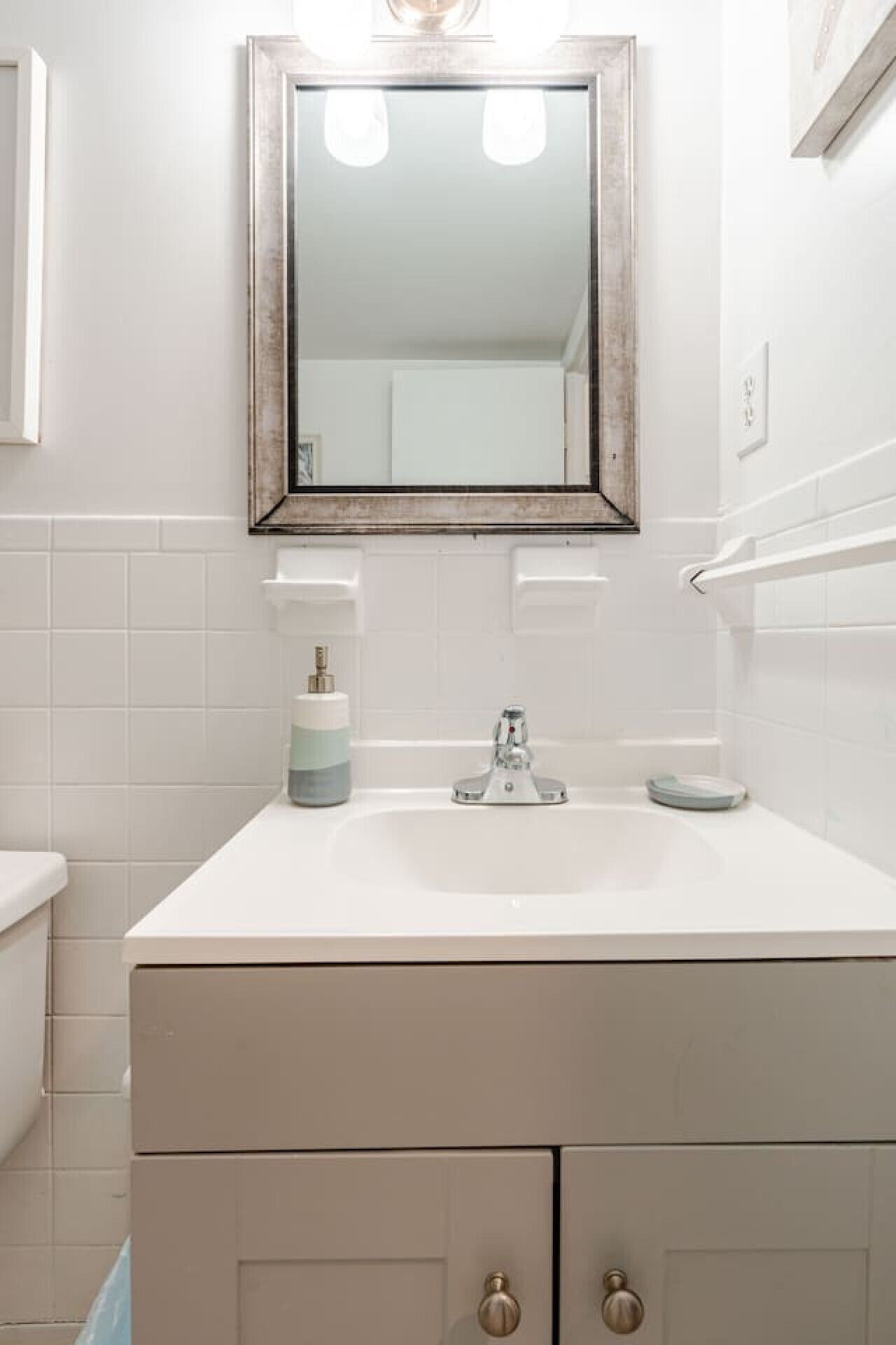 A bathroom with a white sink, a mirror, and a toilet.