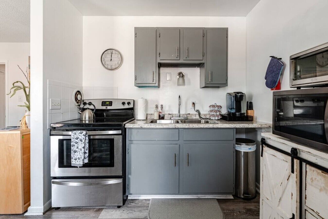 Una cocina compacta con estufa, horno, lavabo y microondas.