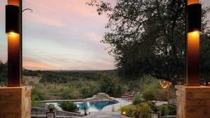 A pool area with a stone pathway leading to a pool, surrounded by greenery and a view of the landscape. - Hill Country Estate on 11 Acres near Dripping Springs and Wimberley (Wimberley)