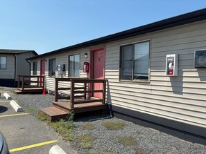 A row of mobile homes with wooden decks and red doors, each equipped with a fire extinguisher. - Trail Motel (Ruckersville)