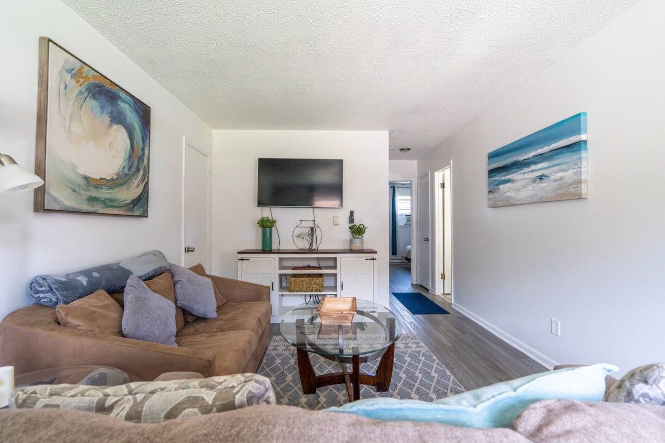A modern living room with a sofa, a coffee table, and artwork on the walls.