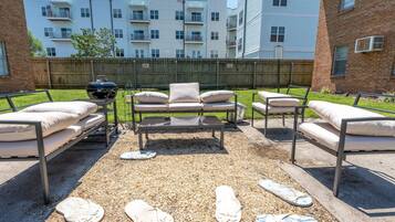 An outdoor patio area with a sofa set, a table, and a grill.