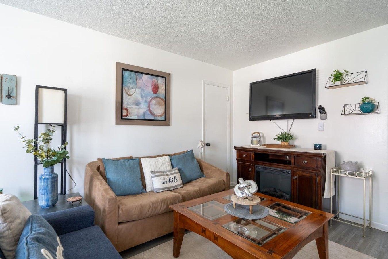 A living room with a sofa, coffee table, fireplace, TV, and decorative items.