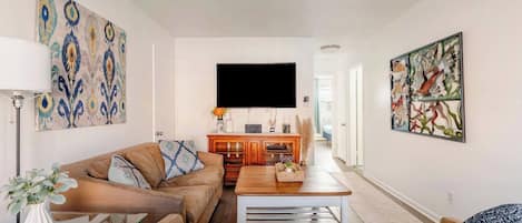 A living room with a sofa, a coffee table, and a TV.