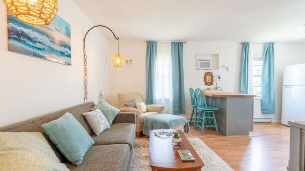 Ein gemütliches Wohnzimmer mit einer Couch, einem Couchtisch und einem Essbereich mit Stühlen.