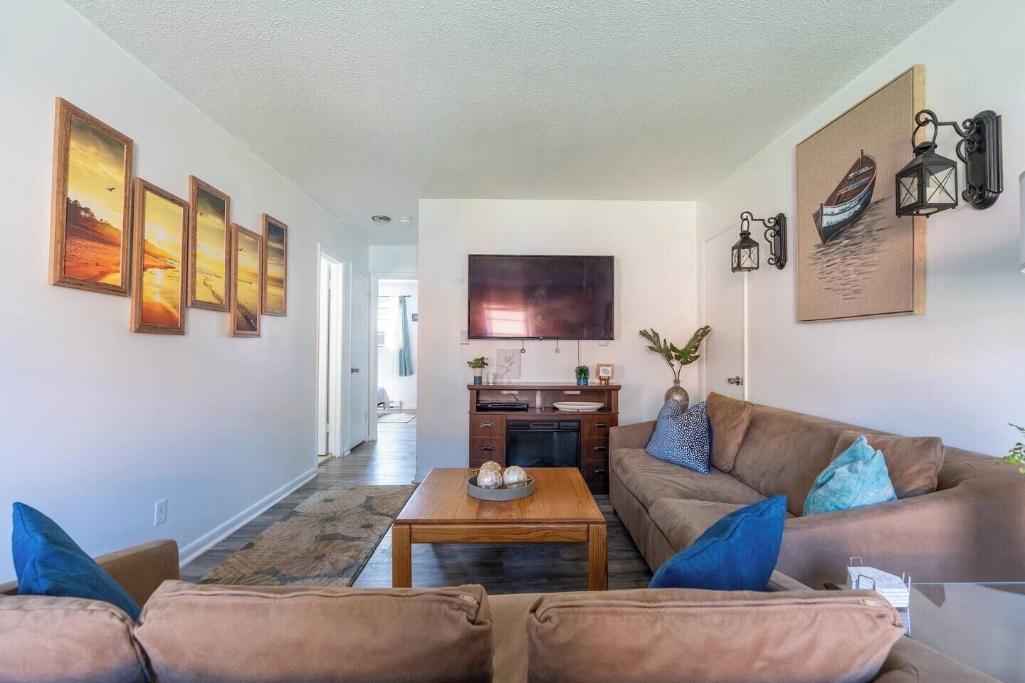 A living room with a sofa, coffee table, and artwork on the walls.