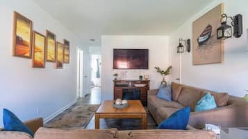 A living room with a sofa, coffee table, and artwork on the walls.