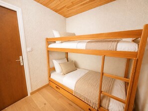 A bunk bed with a wooden frame, white bedding, and a beige throw blanket. - À proximité des pistes | Vue sur la montagne (Les Deux Alpes)