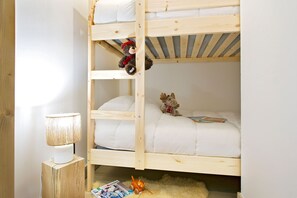 Ein Etagenbett mit einem Teddybären oben und einem Stofftier unten.