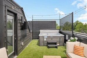 A rooftop patio with a hot tub, artificial grass, outdoor seating, and a view of the sky. - NEW Luxury home with rooftop hot tub and spa like bathroom (Nashville)