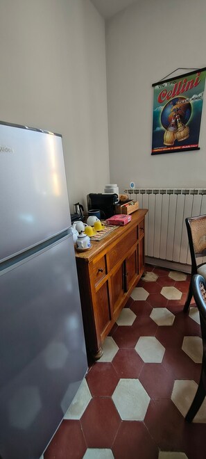 Une cuisine équipée d’un réfrigérateur, d’un meuble en bois et d’une affiche accrochée au mur.