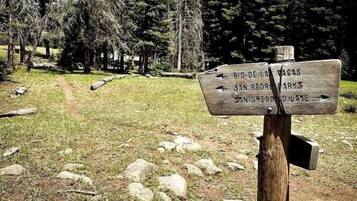 A wooden signpost with directional information in a forested area.