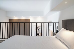 Un dormitorio moderno con una cama grande, cabecera y barandilla.