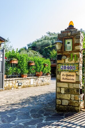 Un portail d’entrée en pierre surmonté d’une enseigne indiquant « Le Gattaie Bellavista » et portant le numéro de maison « 2040H ».