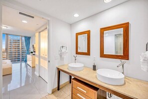 Ein modernes Badezimmer mit zwei Waschbecken, Holzspiegeln und einer Duschkabine aus Glas.