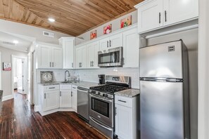 A kitchen with white cabinets, stainless steel appliances, a wooden ceiling, and a granite countertop. - 3BR | Steps to Beach & Boardwalk (Atlantic City)