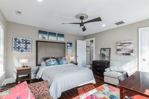 A bedroom with a bed, bedside tables, a dresser, a chair, and artwork on the walls. - 3BR | Steps to Beach & Boardwalk (Atlantic City)