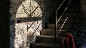 Eine Treppe mit Steinwänden und einem Metallgeländer.