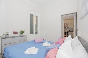 A bedroom with a bed, pillows, a dresser, and a radiator. - Maison Sirivle 7.2 Apartment with Private Terrace and Wi-Fi (Genoa)