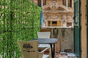 A table and chairs set up outdoors with a green leafy wall behind. - Maison Sirivle 7.2 Apartment with Private Terrace and Wi-Fi (Genoa)