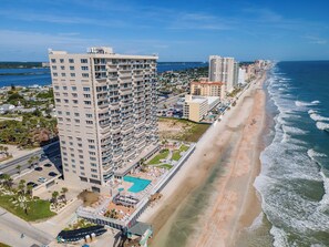 A high-rise hotel with multiple balconies, a swimming pool, and a beach view. - 🌴Panoramic Ocean + River Views 19th Floor Corner Condo - Towers Ten 1901 (Daytona Beach Shores)