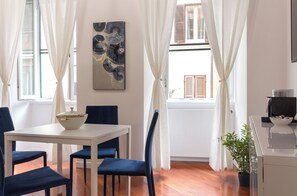 A dining area with a table, chairs, a bowl, and a painting on the wall. - Trastevere | Piazza Trilussa | Rome on Foot—Moro7— (Roma)
