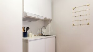 A small kitchen with white cabinetry, a stainless steel sink, and a wall-mounted drying rack. - Trastevere | Piazza Trilussa | Rome on Foot—Moro7— (Roma)