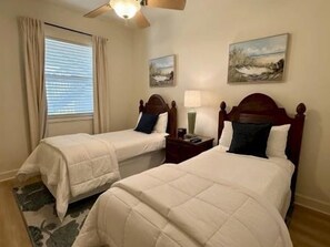 A hotel room with two beds, a nightstand, a lamp, and a window with curtains. - Fairway-View Condo w/ Hammock Beach Resort Access (Palm Coast)